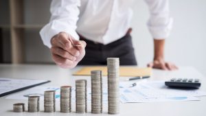 Pilas de monedas apiladas sobre una mesa, simbolizando el aumento progresivo del sueldo de un médico residente en Alemania.