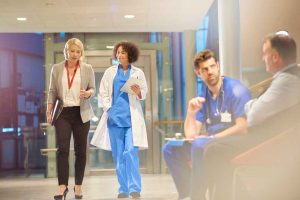 Médicos extranjeros trabajando en un hospital en Alemania, acompañados por personal administrativo.