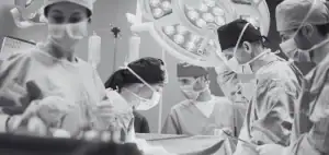 Médicos cirujanos realizando una cirugía, representando la comparación entre ejercer como médico en Colombia y Alemania.