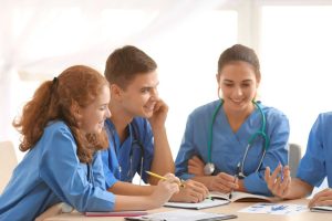Médicos jóvenes estudiando alemán en grupo para trabajar en Alemania