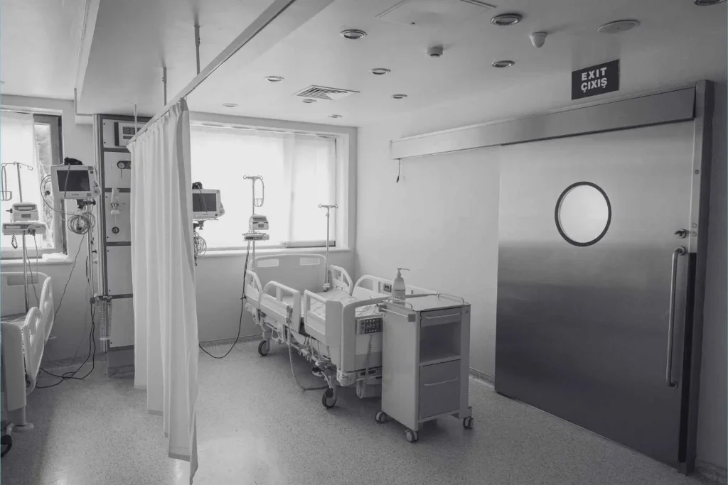 Sala hospitalaria vacía con camas y monitores médicos, representando la escasez de médicos en el mundo.