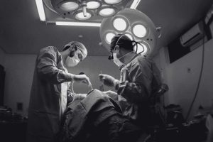 Cirujanos con mascarilla y gorro operando en quirófano moderno en Alemania