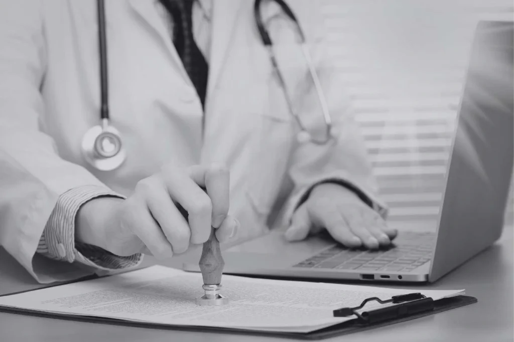 Médico firmando documentos para proceso de Approbation en Alemania