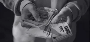 Manos sosteniendo billetes en euros representando el salario de enfermeras en Alemania en 2026