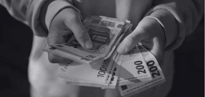 Manos sosteniendo billetes en euros representando el salario de enfermeras en Alemania en 2026