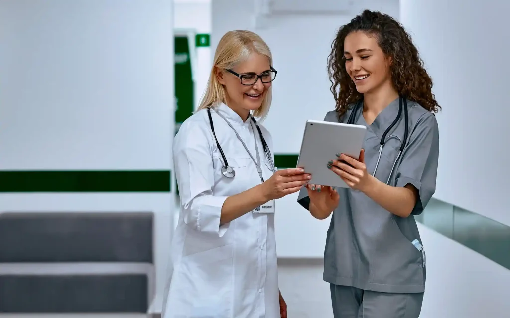 Médicas revisando una tablet en un hospital mientras se presentan los servicios incluidos en el Programa ZAI para homologación y especialización médica en Alemania.